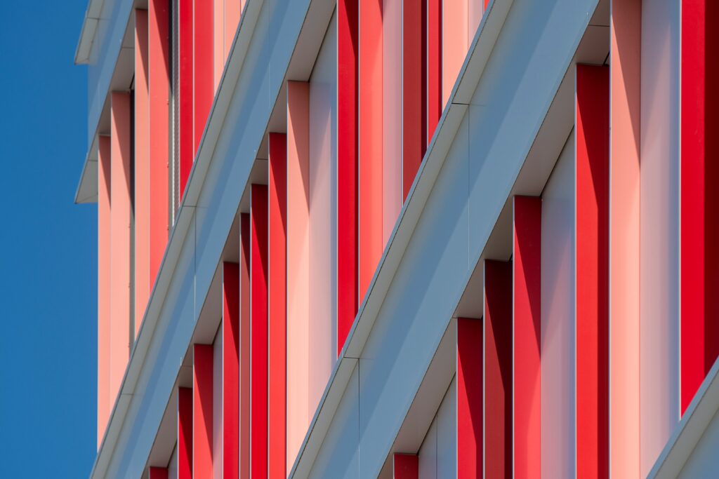 Détail architectural composé de lignes rouges, blanches et bleues répétées